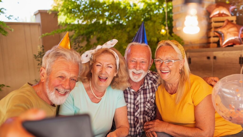 Senior friends taking a selfie while celebrating birthday